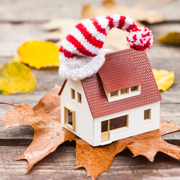 Cappotto Termico Esterno Milano -  Modellino casa con cappello di lana su una foglia autunnale